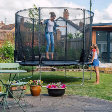 Adult jumping in the Plum Space Zone II Evolution Springsafe Trampoline and enclosure.