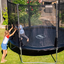Kid jumping in the Plum Space Zone II Evolution  Springsafe Trampoline and enclosure.