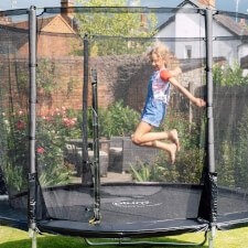 Kid jumping in the Plum Space Zone II Evolution Springsafe Trampoline and enclosure.
