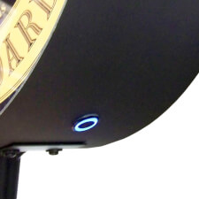 The Champion Shuffleboard rail mount unit button close up.