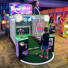 Kid Playing World Football Pro Arcade Machine.