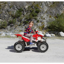 Kid enjoying Polaris Outlaw 330W Ride On Motorbike in Red.