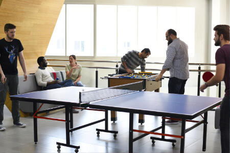 A table tennis table in an office breakout area.