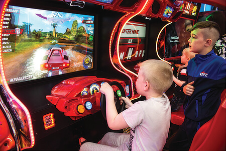 An arcade machine being played by children.