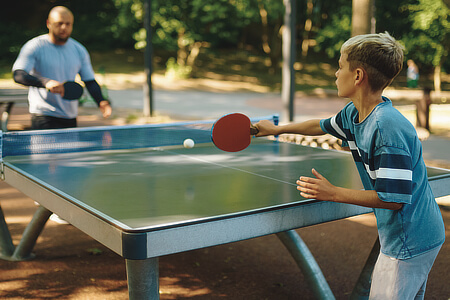 Playing table tennis in the sun.